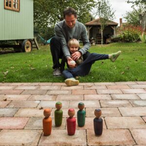Father and son playing with a wooden skittle game.