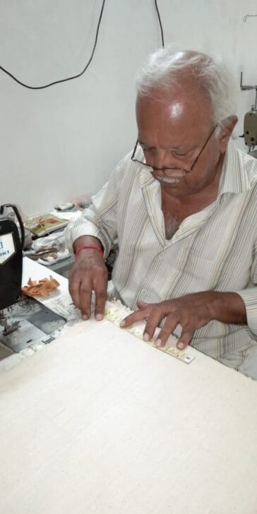 A man measuring cotton with a ruler to make Love Heartwood cotton bags.