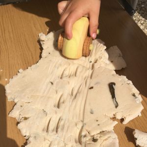wooden car making tracks in play dough
