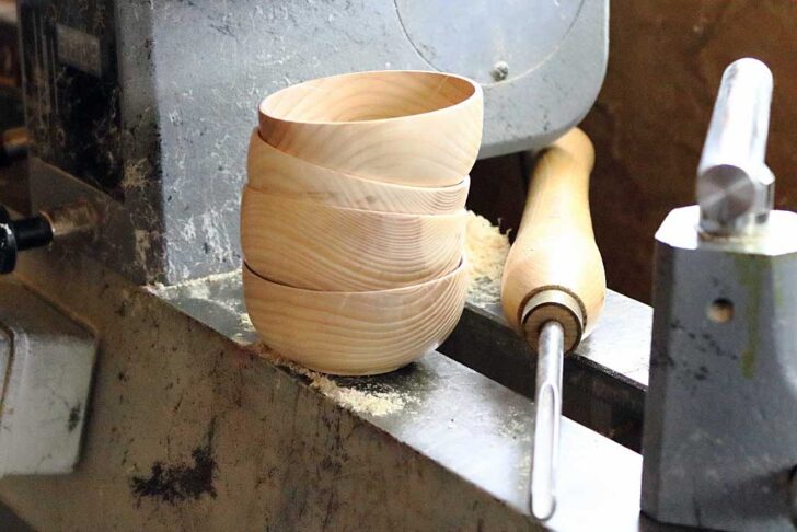 one ash project wooden bowls on the lathe with a gouge