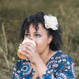 woman drinking from a wooden cup