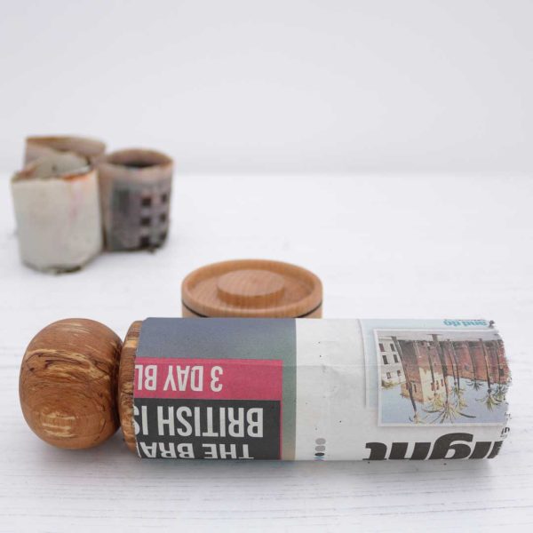 a strip of newspaper wrapped around a seed pot mould