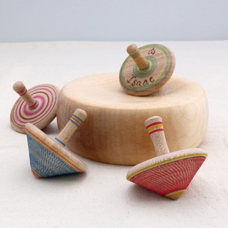 coloured spinning tops around a wooden base