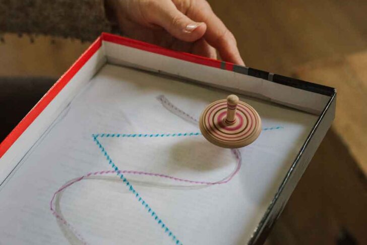 spinning top following a path drawn on a piece of paper