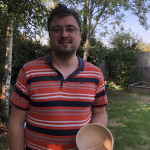 Man holding a wooden dish he made himself