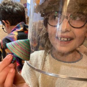Girl holds wooden top she made herself