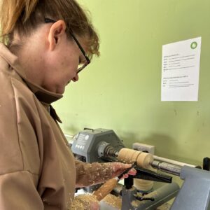Woman at the woodworking lathe.