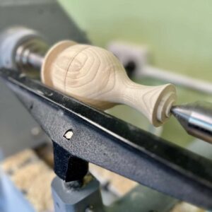 Turning a wooden bud vase on the lathe.