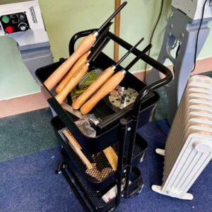 A trolley holding a set of woodturning tools, a chuck and other turning equipment.