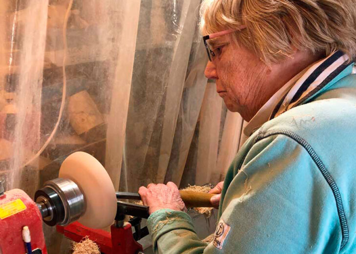 Older adult enjoying the benefits of woodturning in later life at a lathe.