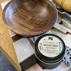 a pot of nc beeswax next to a walnut wood bowl