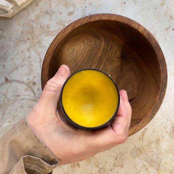 nc beeswax in a pot above a walnut wood bowl