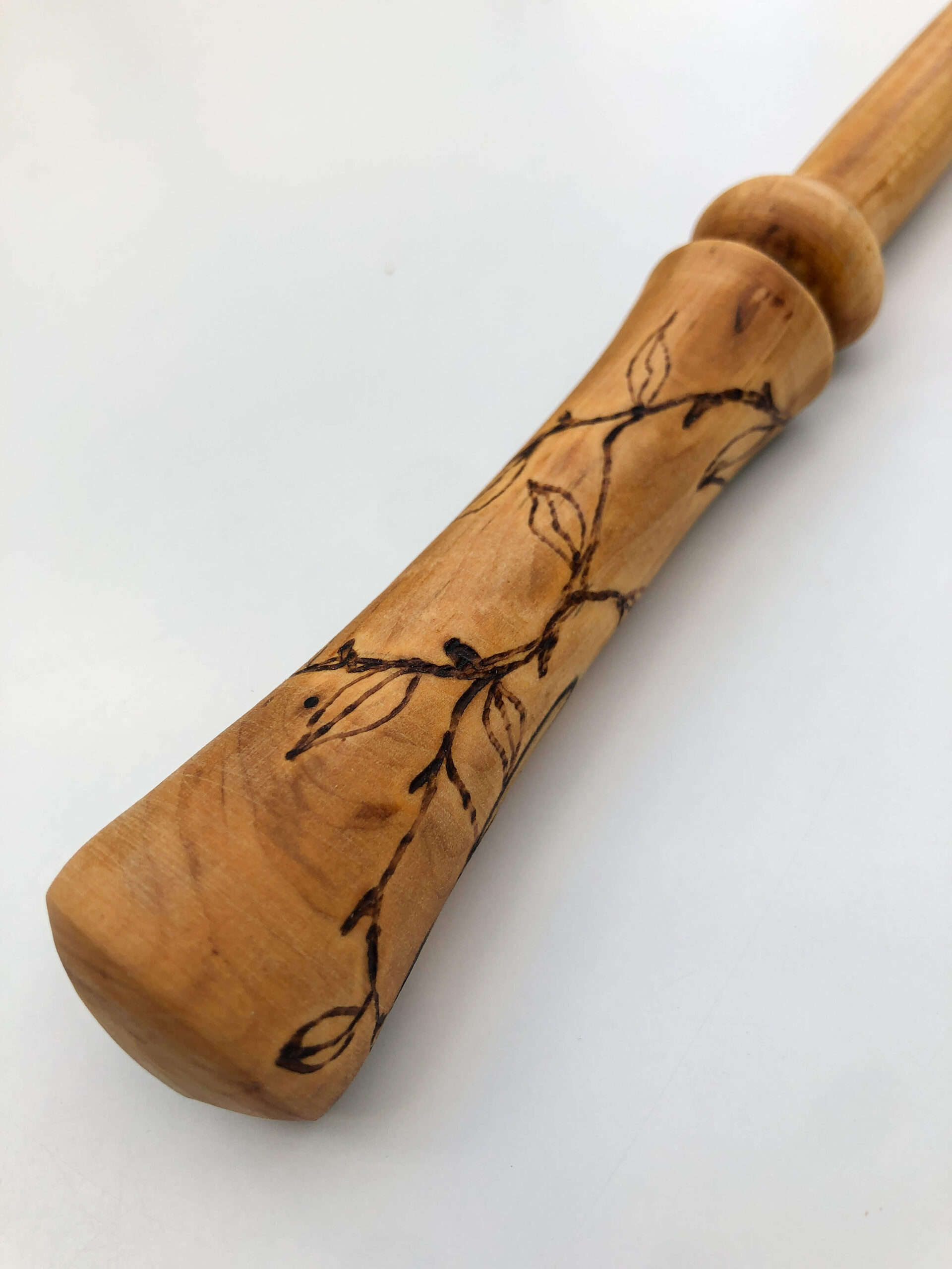 A wooden wand handle featuring a decorative design