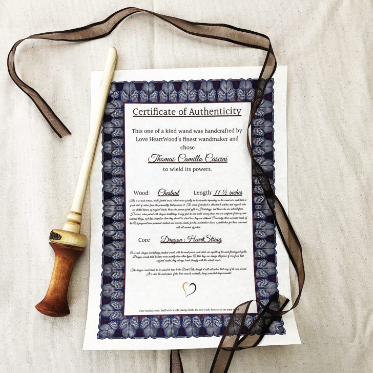 A certificate of authenticity and a wand resting on a bed