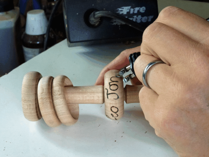 Liz engraving a wooden rattle