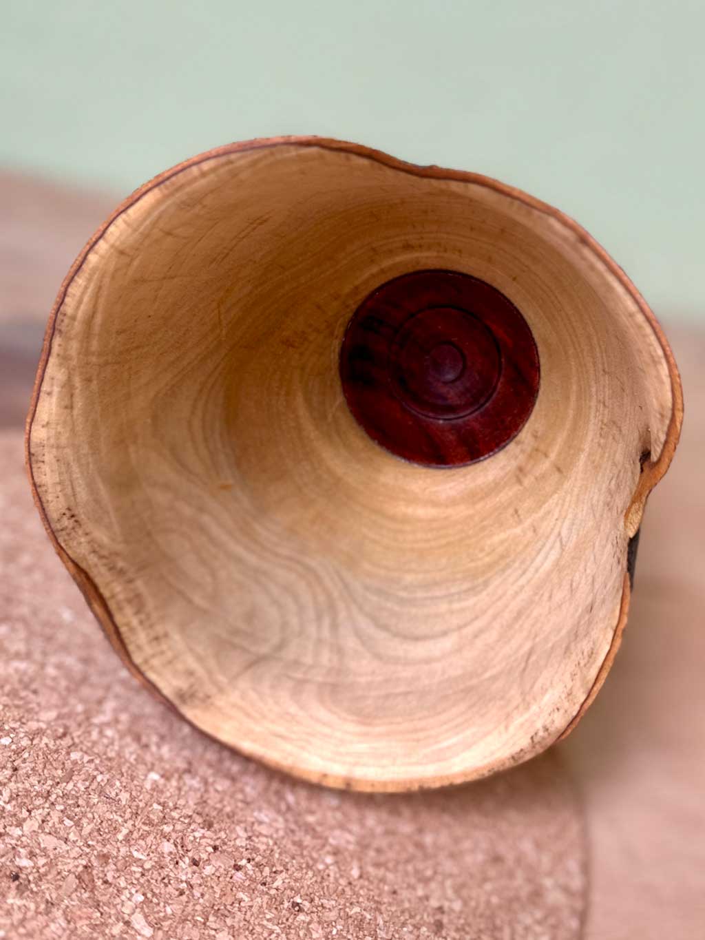 Inside of natural edged end grain Bay wood vessel with rosewood foot.