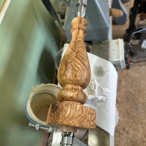 Sanding a handmade wooden table lamp before applying the finish.
