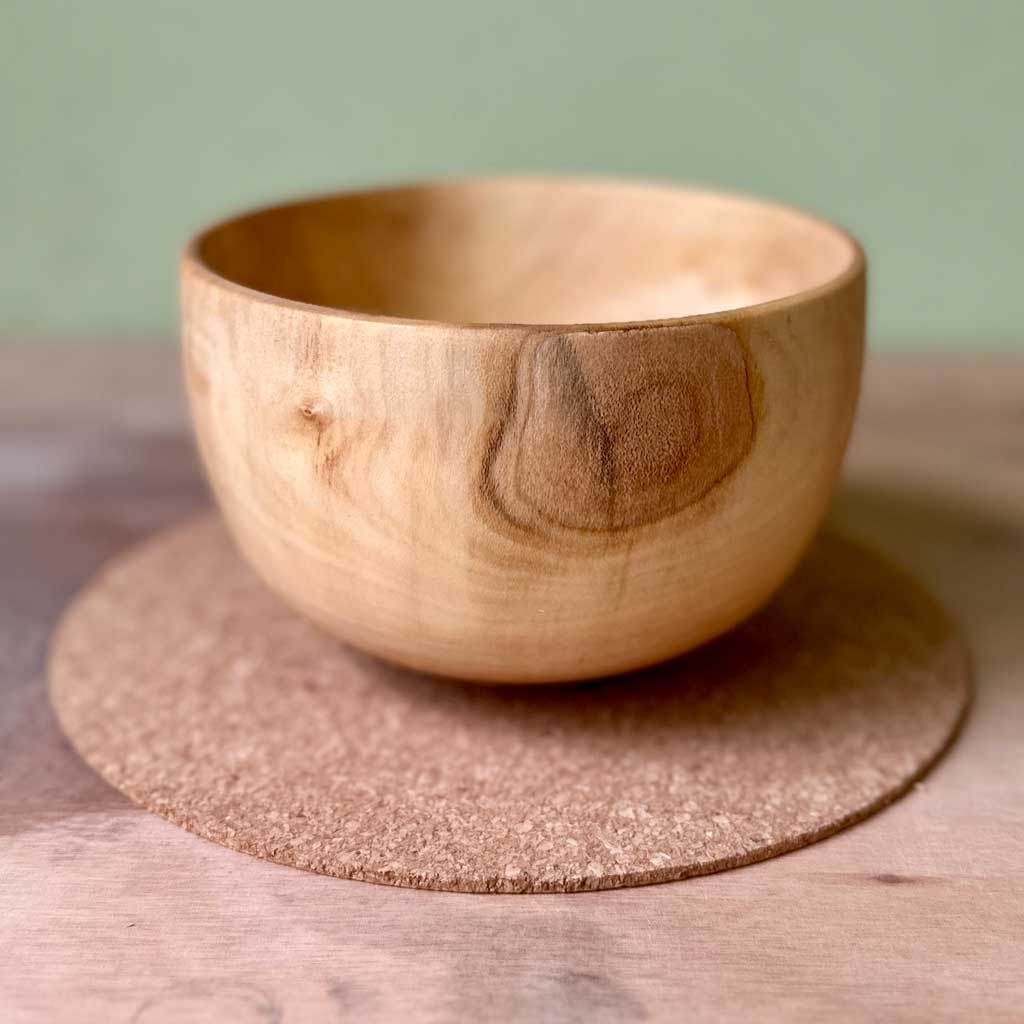 Gathered hand turned sycamore vessel with subtle natural grain and rounded form.