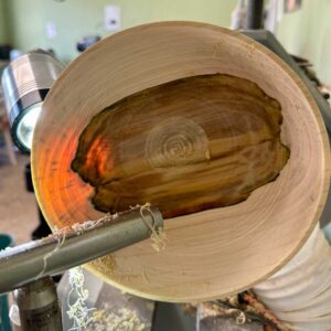 Close-up of the Rooted vessel being turned, revealing the natural rowan heartwood.