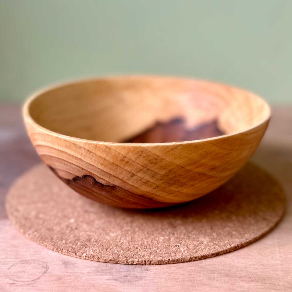 Rooted hand turned green rowan wood vessel with natural heartwood feature.