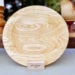 Hand turned ash serving platter with pale natural grain and broad contemporary form.