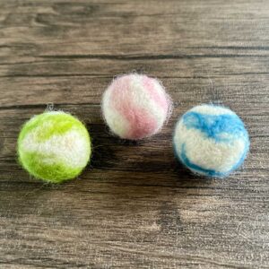Three hand felted woollen balls in pink, blue and green.